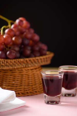 Red grape juice in glass with grape fruitの写真素材