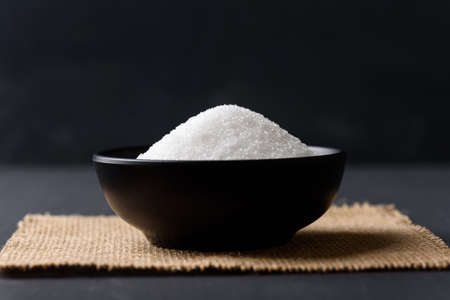 White granulated sugar on black backgroundの写真素材