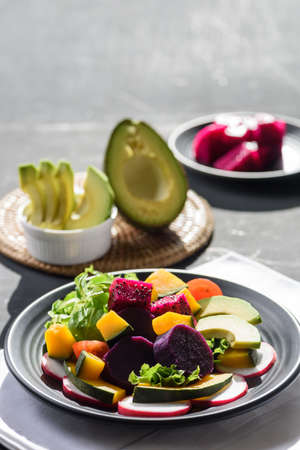 Fresh fruit and vegetable salad with avocado, dragon fruit, pumpkin, tomato, radish, lettuce and...