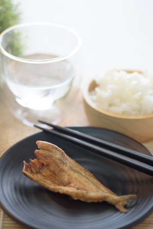 Fried dry fish on black dish, Asian cuisineの写真素材