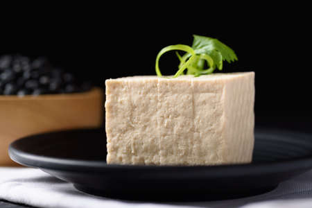 Fresh tofu made from organic soybeans is an ingredient in plant based as a healthy and vegetarian...