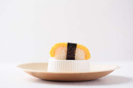 Nigiri sushi in a plate made from tree leaf on a white background is a cultural food of Japan, Asia.