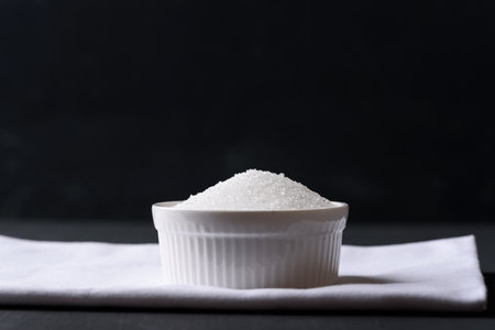 White granulated sugar on black backgroundの写真素材