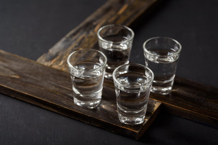 Vodka in a shot glass on black backgroundの写真素材