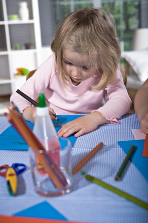 the young girl drawing at a tableの写真素材