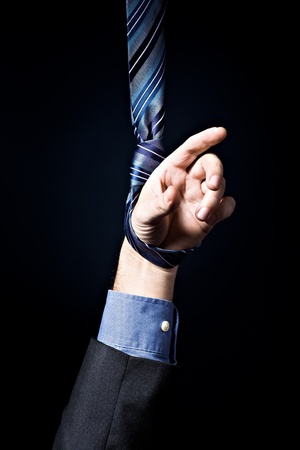 Symbolic picture with mans hand hanging in the nooseの写真素材
