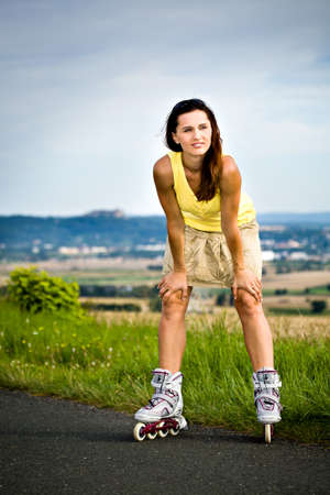 young woman skating with roller skates in a park
