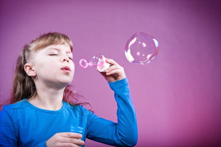 a little girl blowing soap bubbles