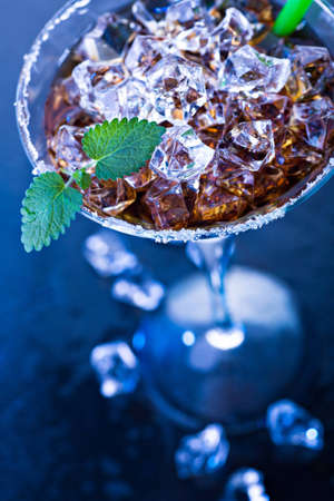 a glas with a rum, ice and lime cocktailの写真素材