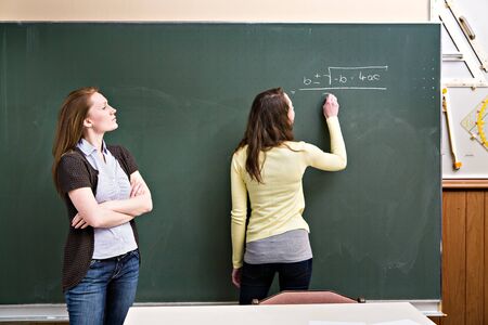 portrait of a young female teacher and a schoolgirl in the classroom
