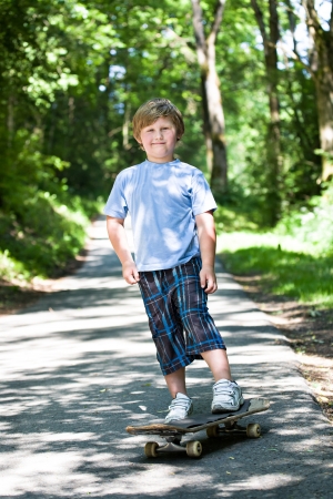 6-year-old boy with a scateboard on the parkwayの写真素材