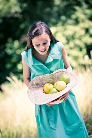 outdoor portrait of a young girl with applesの写真素材