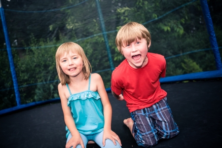 jupming kids on the trampoline in the gardenの写真素材