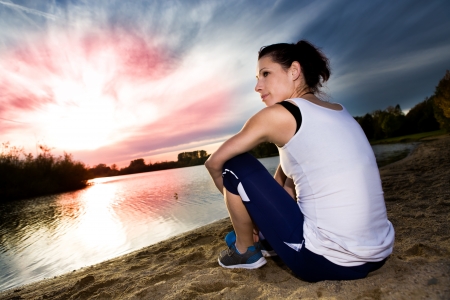 A woman taking a break at lakeの写真素材