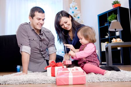 a young family getting Christmas giftsの写真素材