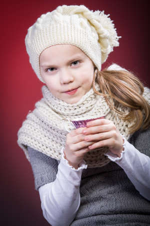 studio portrait of young girl with a cupの写真素材
