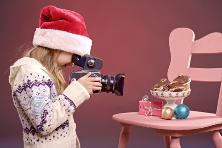 little girl making photos of Christmas decorationの写真素材