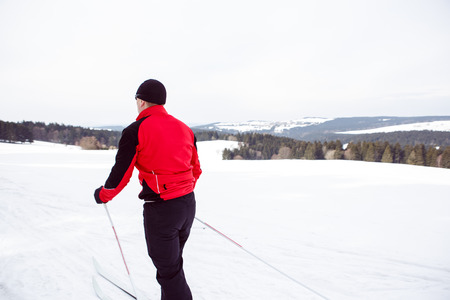 A man cross-country skiing in front of winter landscapeの写真素材