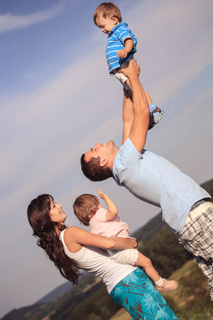 young family on the meadow at sunny dayの写真素材