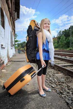 girl waiting for the train on the railway stationの写真素材