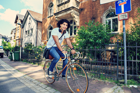 portrait of young male student with a bicycle in the townの写真素材