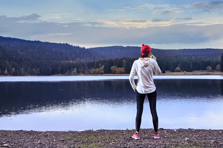 woman running through the forest by the lakeの写真素材
