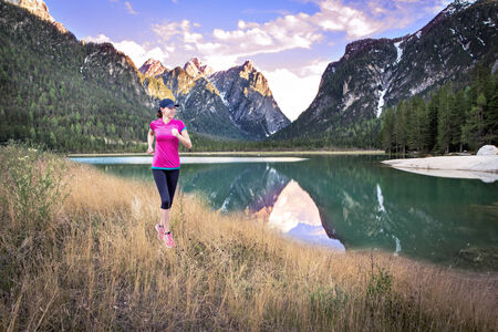 a woman jogging on the rocky trail near a lake
