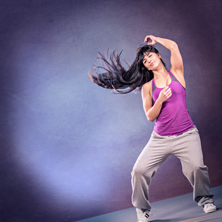 young woman in sport dress dancing zumba