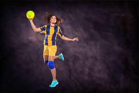 female handball player with a ball on the field