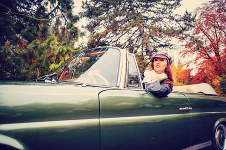 A young woman in front of Post-War classic car