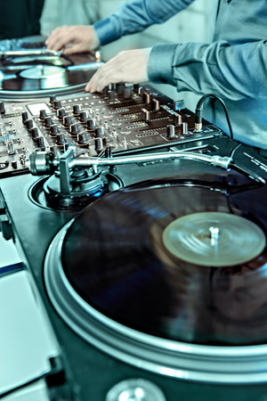 COBURG, GERMANY -  CIRCA MAY, 2015: DJ's hands on equipment deck and mixer with vinyl record at partyのeditorial素材