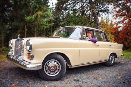COBURG, GERMANY - CIRCA OKTOBER, 2009: A young woman in front of Post-War classic carのeditorial素材