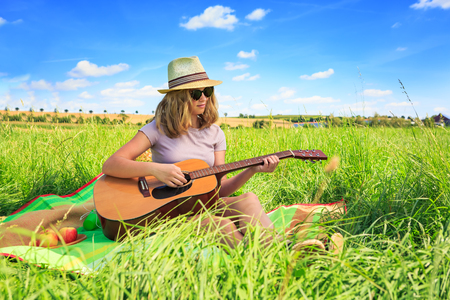 Outdoor portrait of young girl with a guitarの写真素材