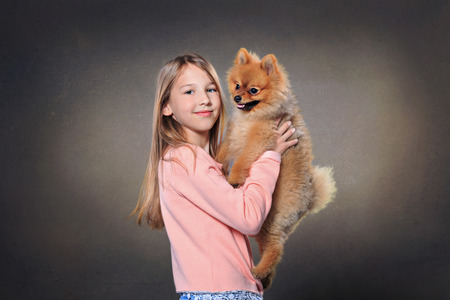 The studio portrait of a teenage girl with pomeranian dogの写真素材