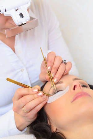 Closeup of a female face by receiving of eyelash lengthening at the beauty salon