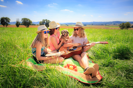 Outdoor portrait of young girls with a guitar