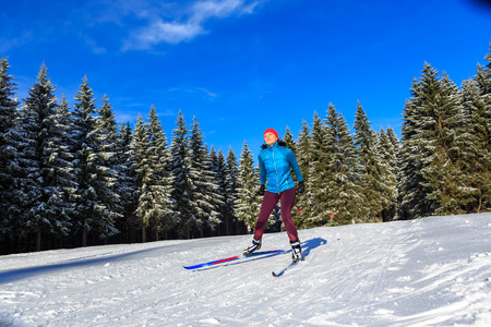 A woman at cross-country skiing or langlauf running in the wintry forestの写真素材