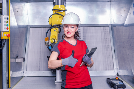 A young female technician while machine constructing in a manufacturing plantの写真素材