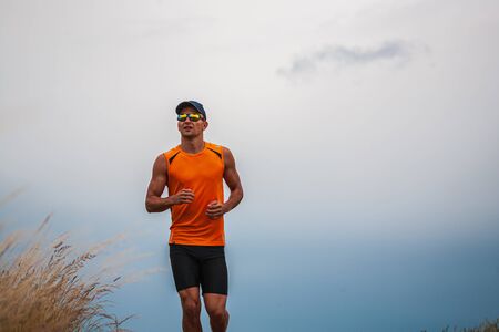 young man jogging through the fields