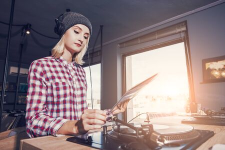 beautiful young woman is browsing and listening a record in the vinyl record storeの写真素材