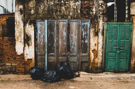 Old and abandonned wall and doors with garbage on the street