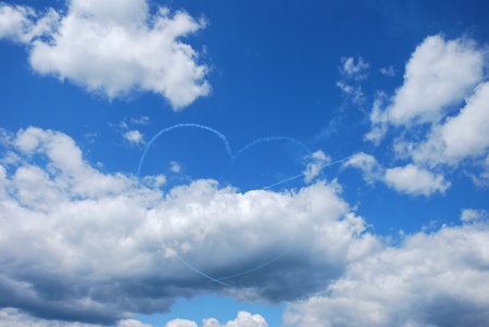 a plane generates with the fog a heart with an arrow at a flight showの写真素材