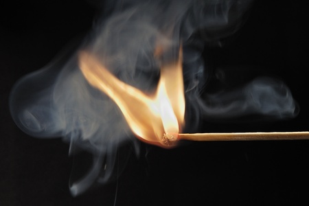 match lit and smoke with black backgroundの写真素材
