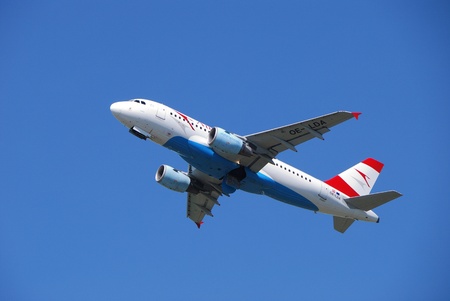 plane of the line austrian airlines at the airport on the air at the blue sky