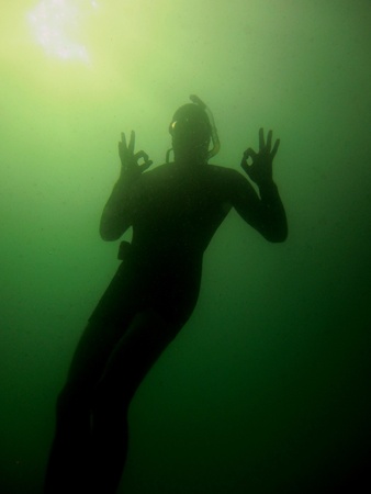 diver in the lake makes ok sign while divingの写真素材