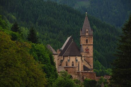 beautiful old church in the middle of the mountains with lots of trees on the right viewの写真素材