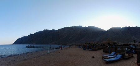 beautiful sandy beach with a jetty and harbor panorama