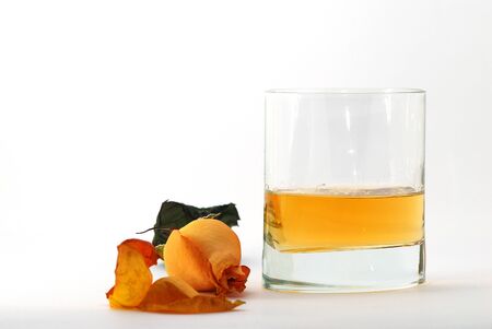 whiskey on a glass with an orange rose white backgroundの写真素材