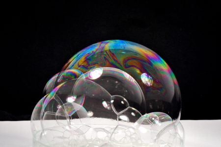 many colorful soap bubbles with black reflective backgroundの写真素材