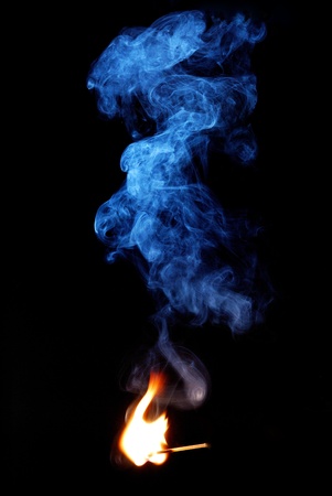 much blue gray smoke of flame on black background with matchの写真素材